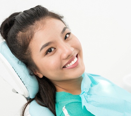 Woman leaning back in dental chair smiling